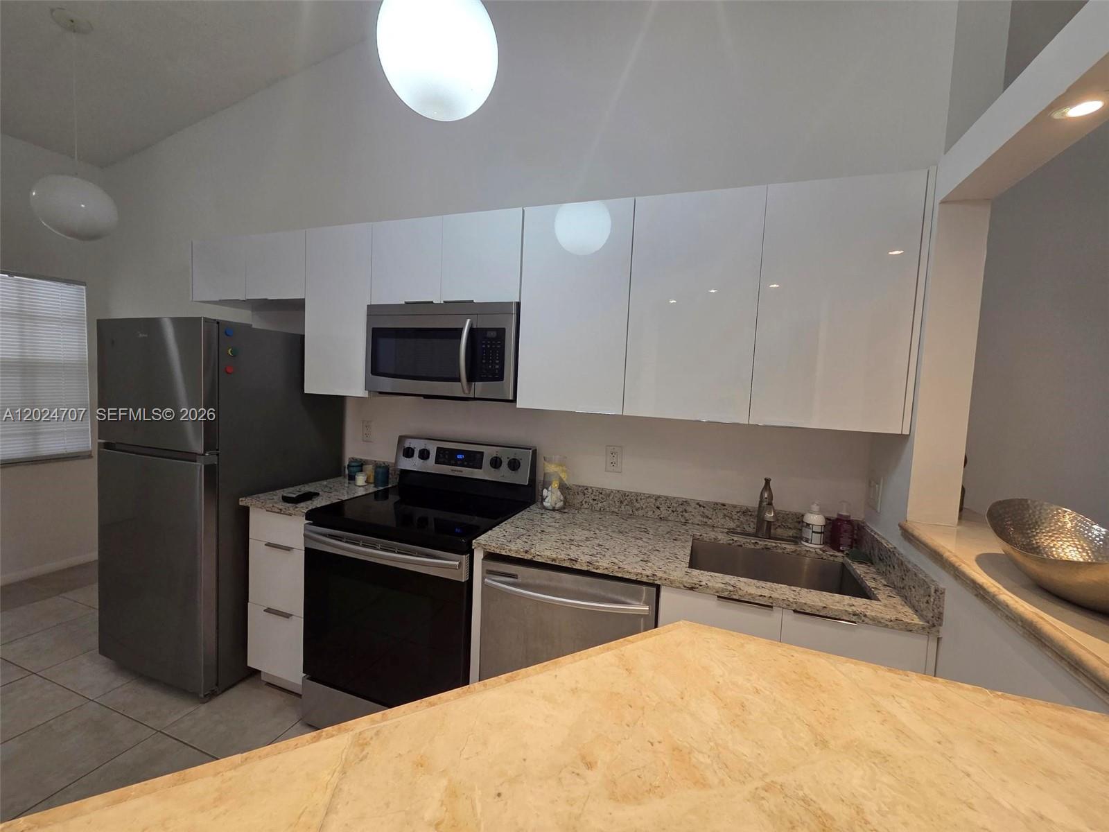 A kitchen features white cabinets, stainless steel appliances, and speckled granite countertops — 3686 NW 83rd Ln # 3686, Sunrise FL 33351, SUNRISE, FL