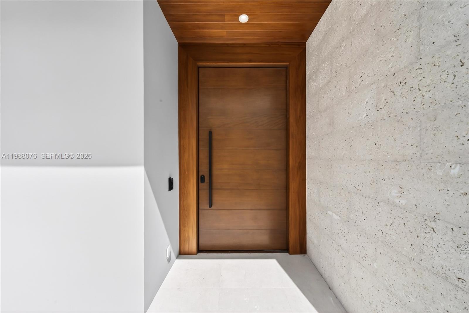 A modern two-story house features a white facade, vertical gray slats, and a wooden door — 609 SW 24th Rd, Miami FL 33129, MIAMI, FL
