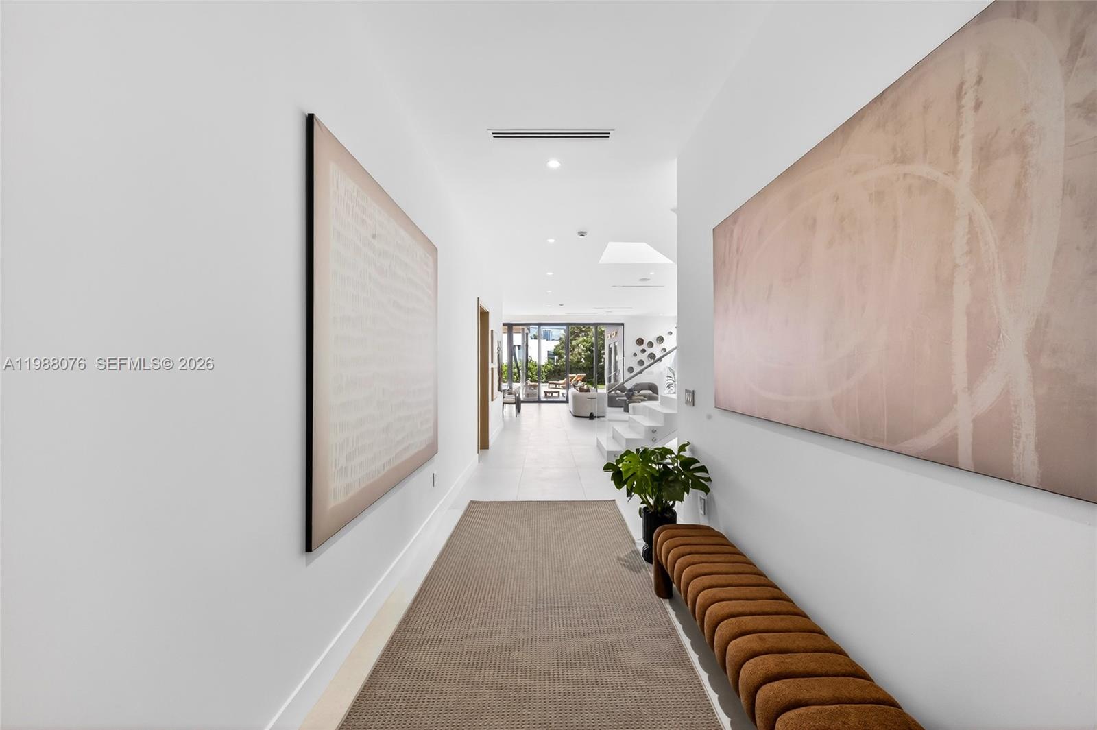 A modern wooden front door is framed by wood paneling and a stone wall — 609 SW 24th Rd, Miami FL 33129, MIAMI, FL