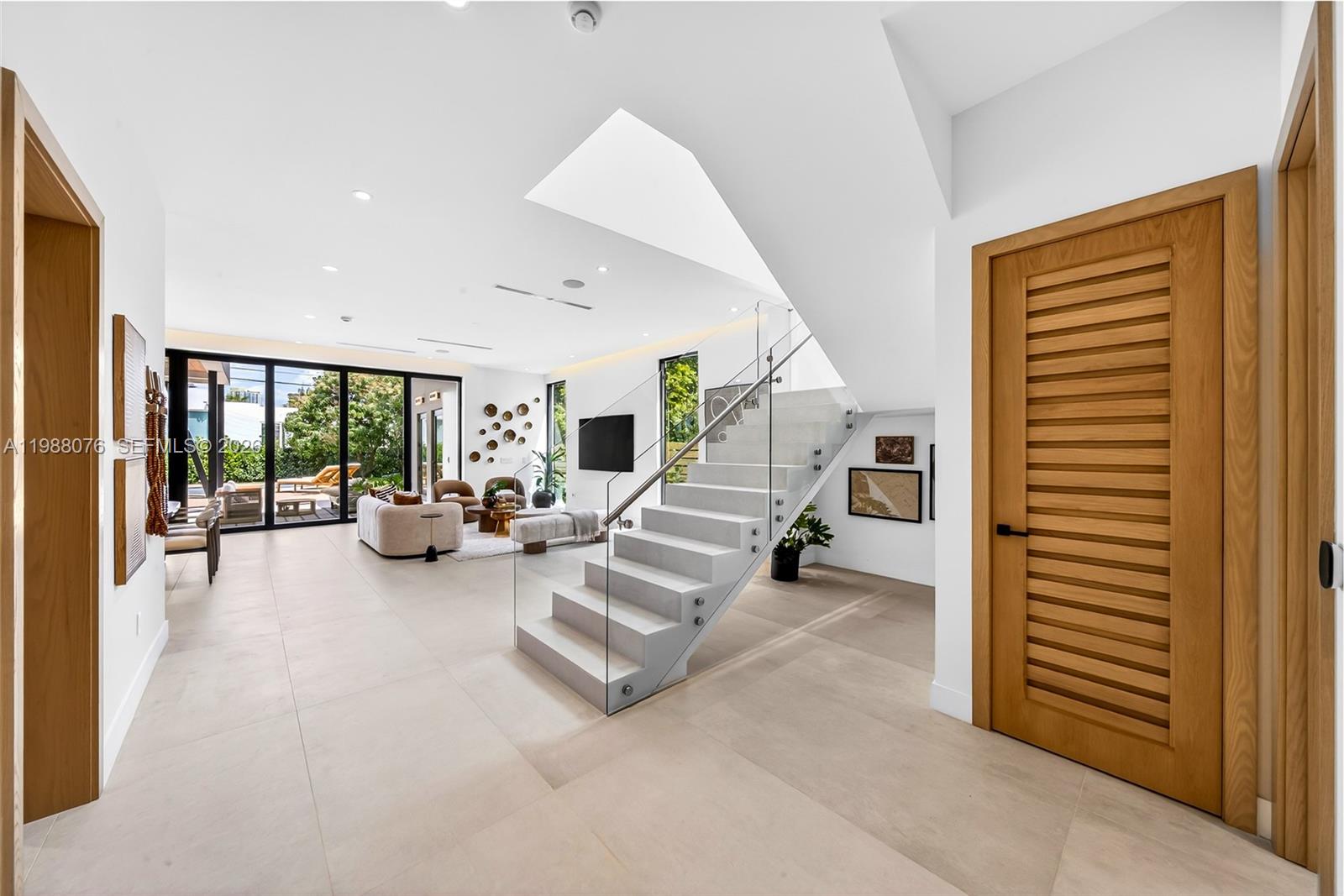A long white hallway features two large abstract paintings, a brown bench, and a rug — 609 SW 24th Rd, Miami FL 33129, MIAMI, FL