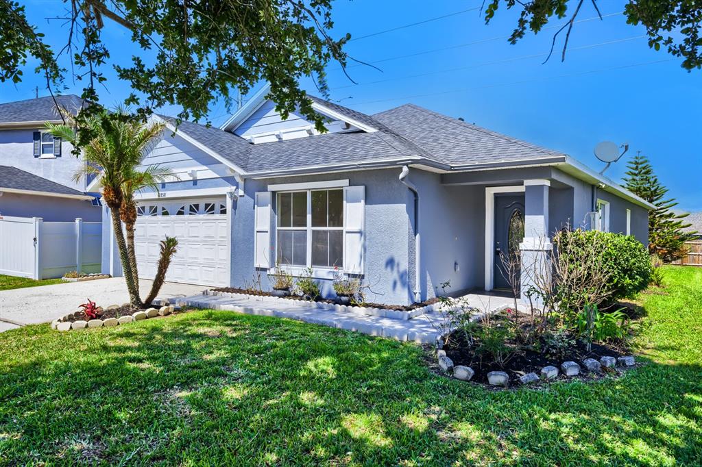 A single-story house with a blue exterior, white shutters, a garage, and a front lawn — 2858 PAYNES PRAIRIE CIRCLE, KISSIMMEE, FL