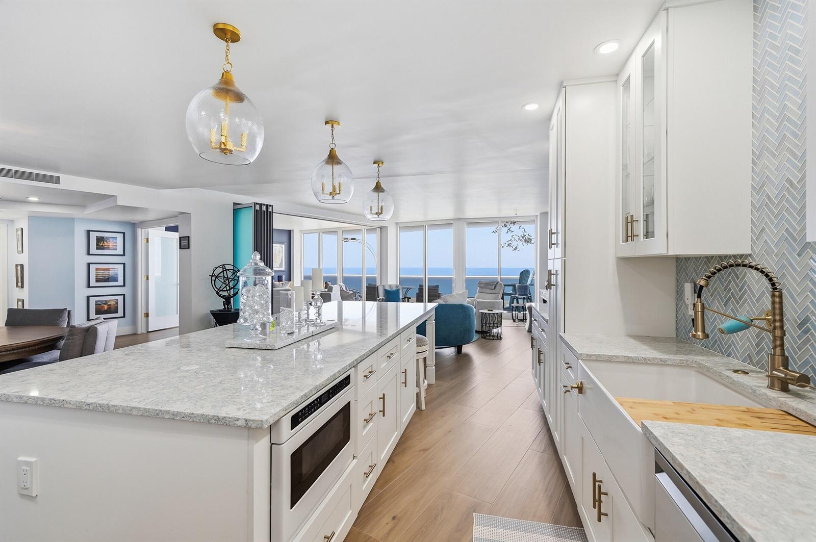 A kitchen with white cabinets, a granite island, and a view of the ocean — 700 S Ocean Boulevard # 803, Boca Raton FL 33432, BOCA RATON, FL