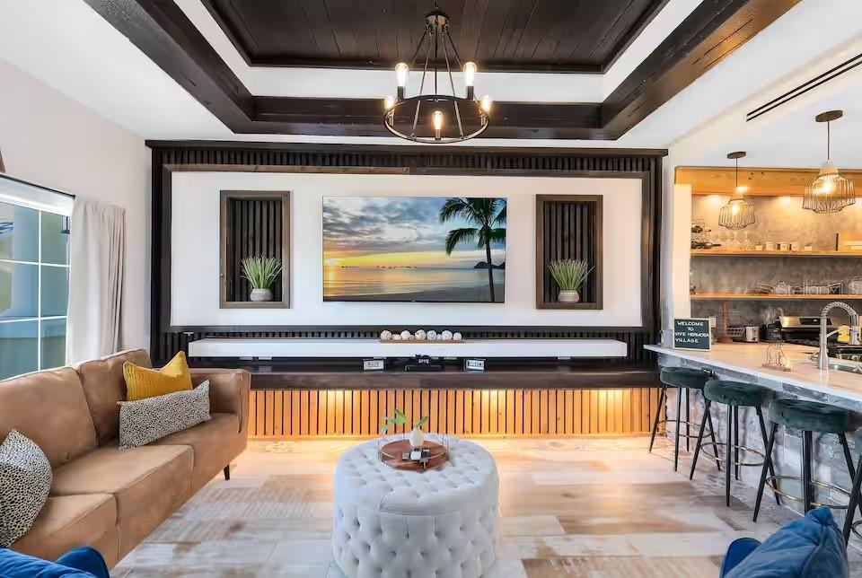 A living room features a wood-slat accent wall, a mounted television, and a coffered ceiling — 1326 SEVEN EAGLES COURT UNIT 1326, KISSIMMEE, FL