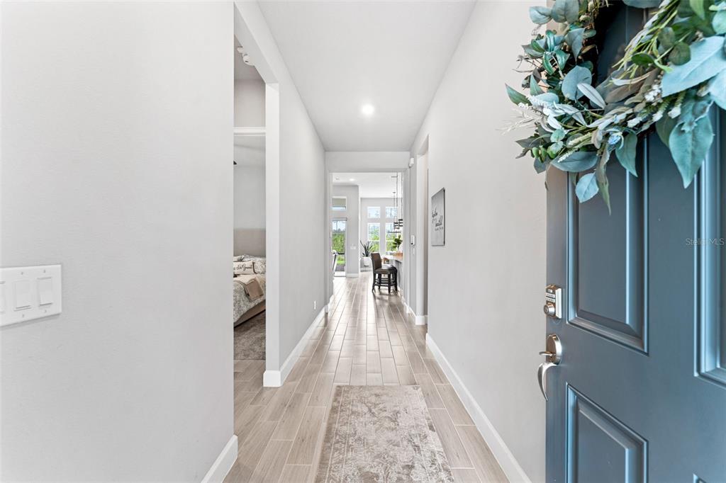 A view from an entryway looking down a hallway with light-colored tile flooring — 257 MOSAIC BOULEVARD, DAYTONA BEACH, FL
