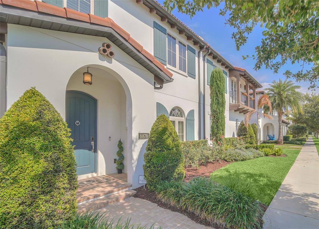 A two-story stucco house features a blue arched front door and green window shutters — 8878 BISMARCK PALM DRIVE, WINTER GARDEN, FL