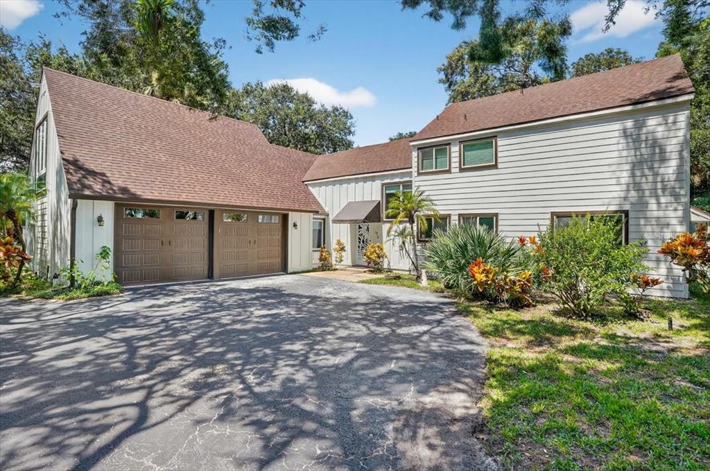 A two-story house with a two-car garage, light siding, and a large asphalt driveway — 120 BEACH STREET, PONCE INLET, FL
