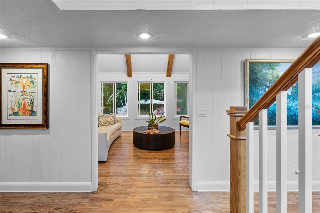 A view through a doorway into a living room with hardwood floors and exposed beams — 120 BEACH STREET, PONCE INLET, FL