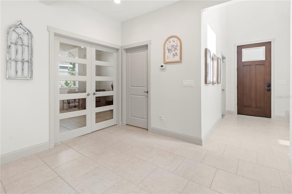 An entryway features light tile flooring, white walls, French doors, a solid interior door, and a wooden front door — 6311 HORSE MILL PLACE, PALMETTO, FL