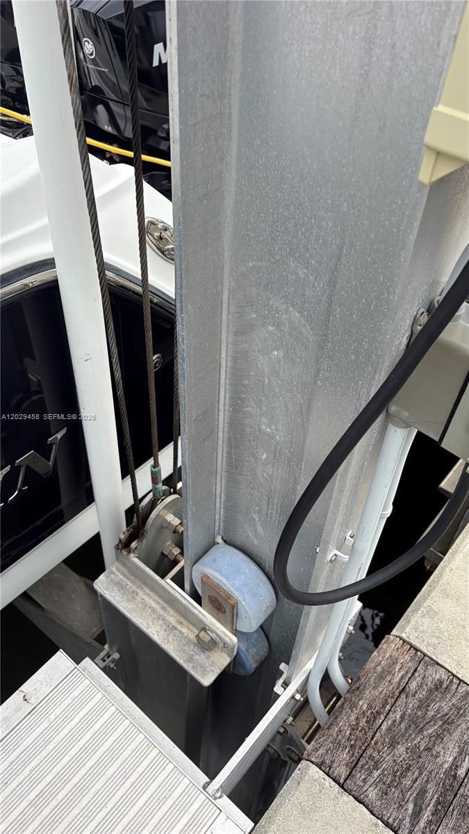 A close-up view shows the metal support beam, guide rollers, and cables of a boat lift — 150 SE 25th Rd, Miami FL 33131, MIAMI, FL