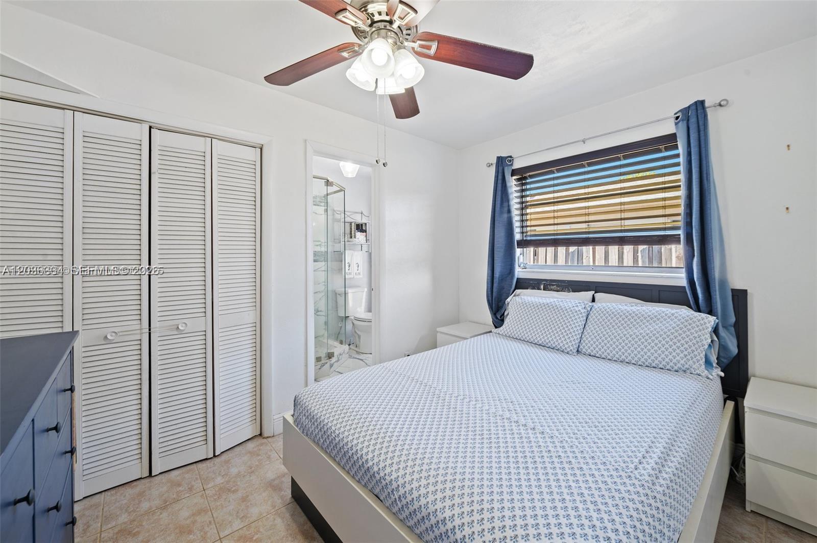 A bedroom features a bed, ceiling fan, closet with louvered doors, and an attached bathroom — 5120 SW 26th Ave # 2, Dania Beach FL 33312, DANIA BEACH, FL