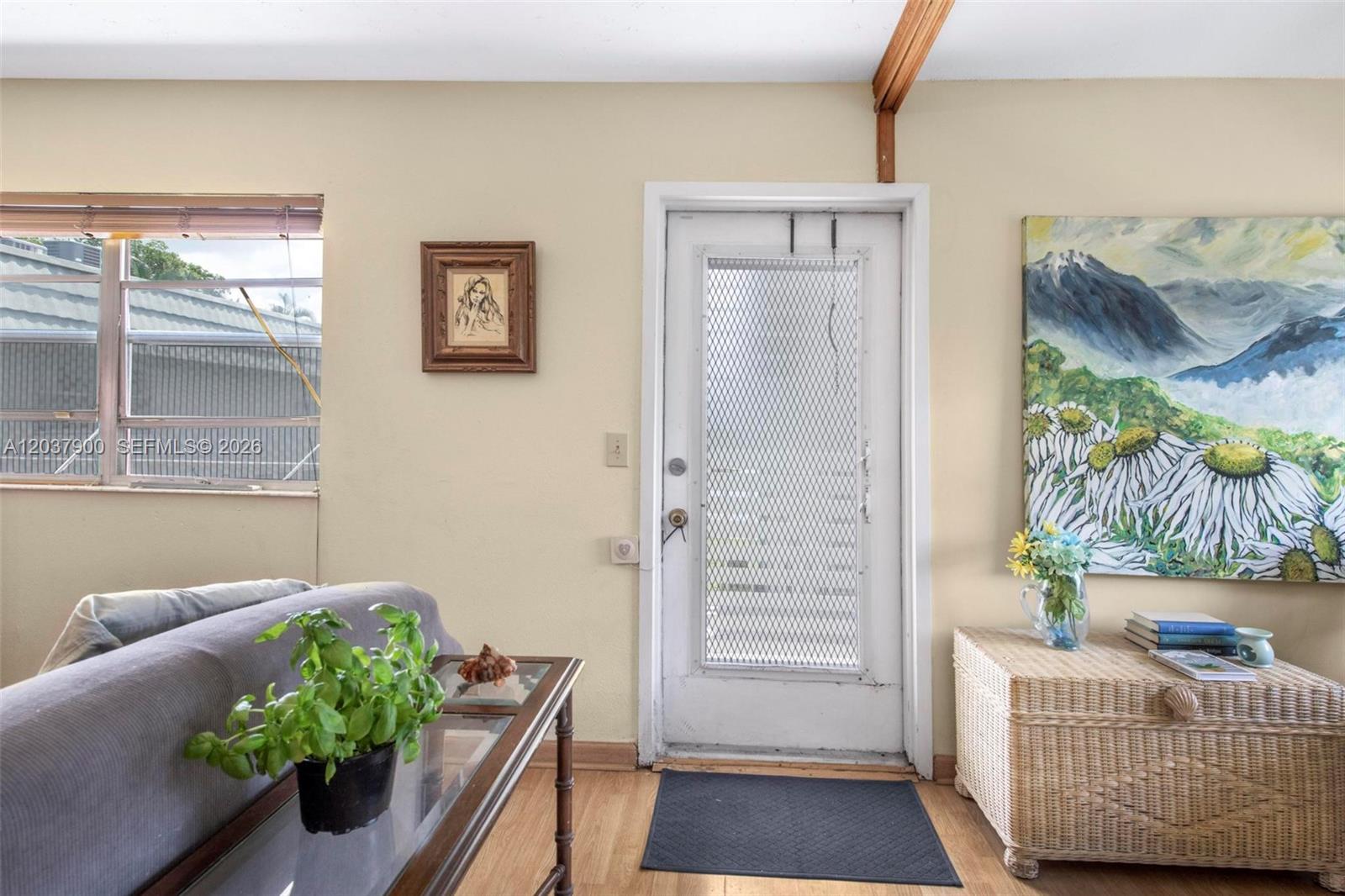 A living room features a white screen door, a wicker chest, and a glass-topped table — 712 Monaco O # 712, Delray Beach FL 33446, DELRAY BEACH, FL
