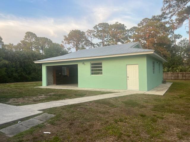 A light green detached garage with a metal roof and a white entry door — 16824 N 130th Ave Avenue N, FL 33478, FL