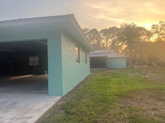 An exterior view of a light green house with an open garage and a backyard — 16824 N 130th Ave Avenue N, FL 33478, FL