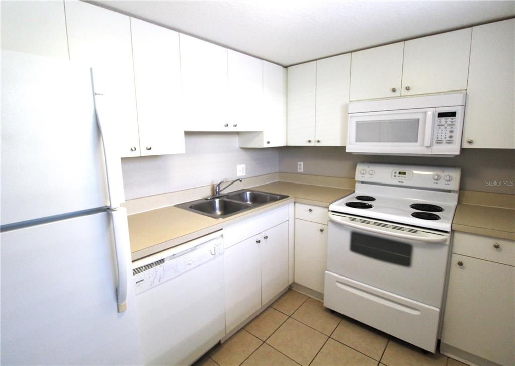 A light blue door with a fire extinguisher mounted beside it on a white exterior wall — 5310 26TH STREET W UNIT 405, BRADENTON, FL