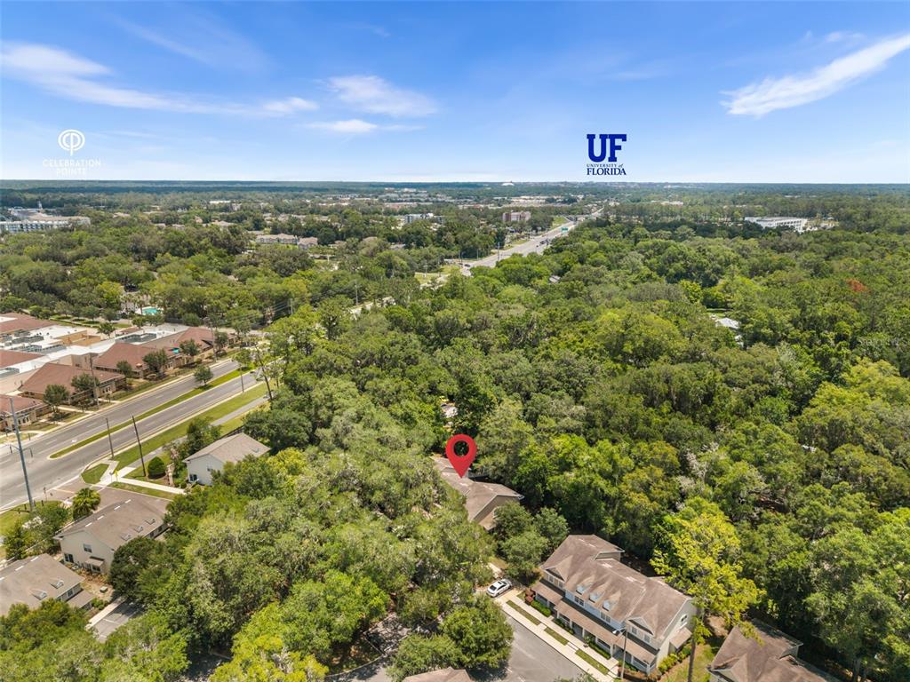 An aerial view shows a residential building surrounded by dense trees near a main road — 4605 SW 48TH DRIVE UNIT 155, GAINESVILLE, FL