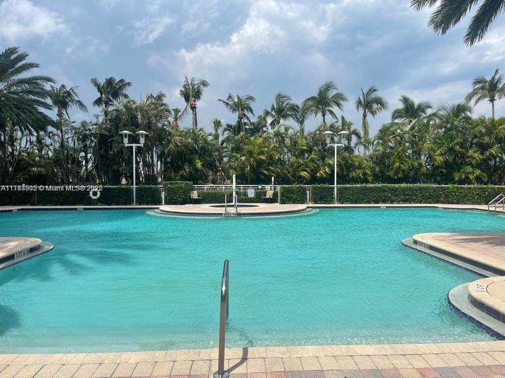 A large outdoor swimming pool is surrounded by palm trees and a paved deck — 1755 E Hallandale Beach Blvd, Hallandale Beach FL 33009, HALLANDALE BEACH, FL