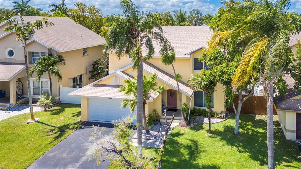 An aerial view of a two-story yellow house with a garage and palm trees — 9601 SW 9TH COURT, PEMBROKE PINES, FL