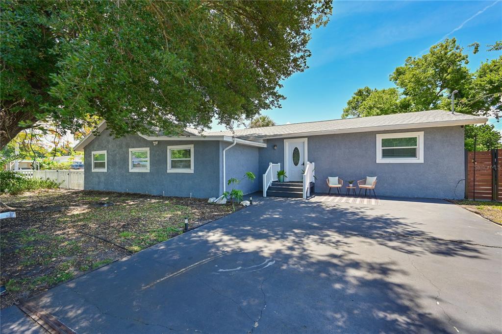 A gray, single-story house with a white front door and a paved driveway — 1423 12TH AVENUE W, PALMETTO, FL