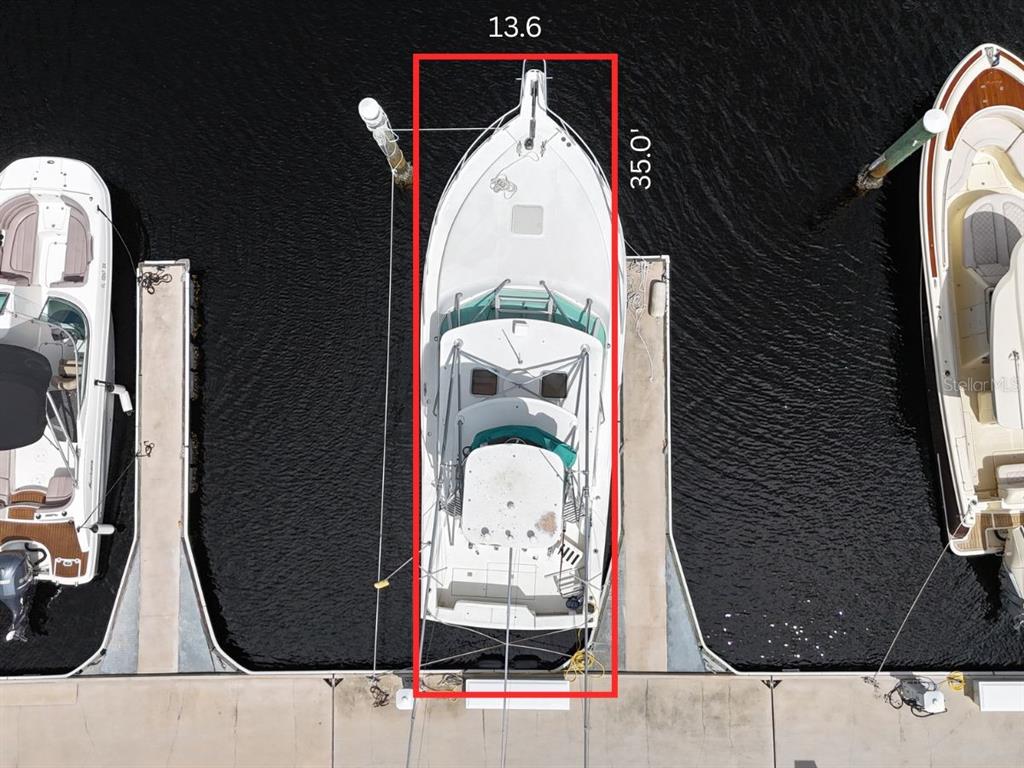 An aerial view shows a boat docked in a slip with dimensions marked in red — 102 RIVIERA DUNES WAY UNIT N-26, PALMETTO, FL