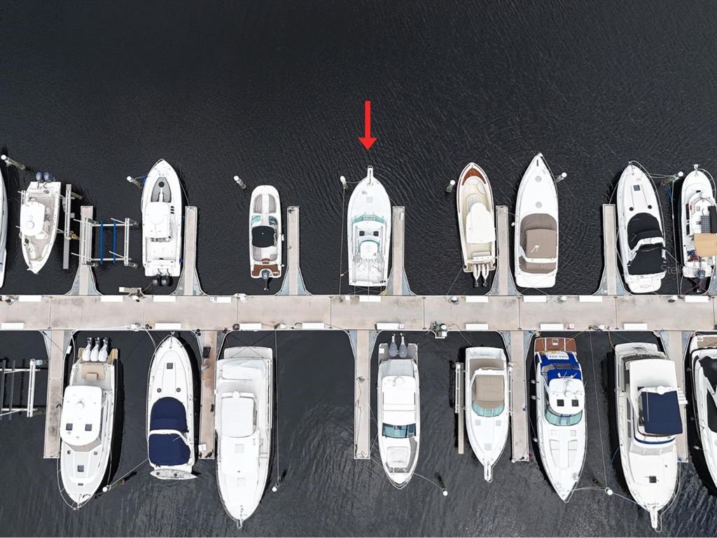 An aerial view shows a row of boats docked at a marina pier — 102 RIVIERA DUNES WAY UNIT N-26, PALMETTO, FL