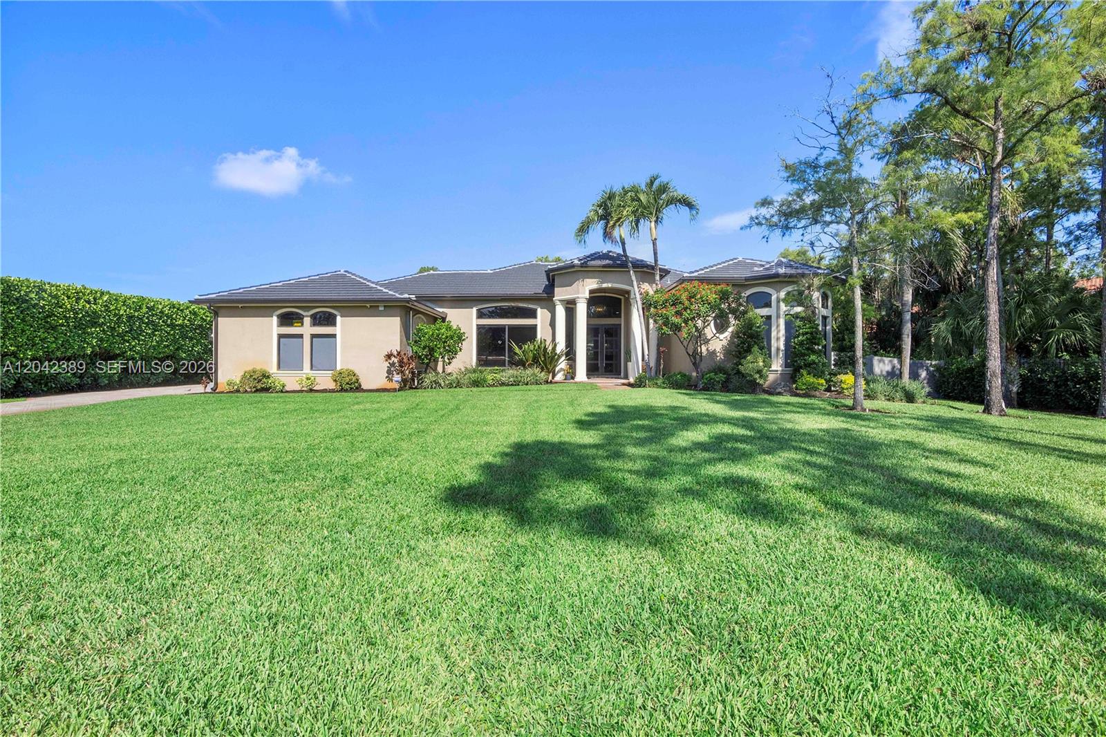 A single-story house with a tiled roof, beige stucco exterior, and a large front lawn — 5755 NW 72nd Way, Parkland FL 33067, PARKLAND, FL