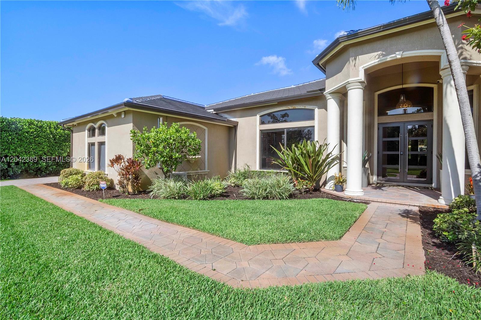 A beige house exterior features a stone walkway, white columns, and a glass-paned double door — 5755 NW 72nd Way, Parkland FL 33067, PARKLAND, FL