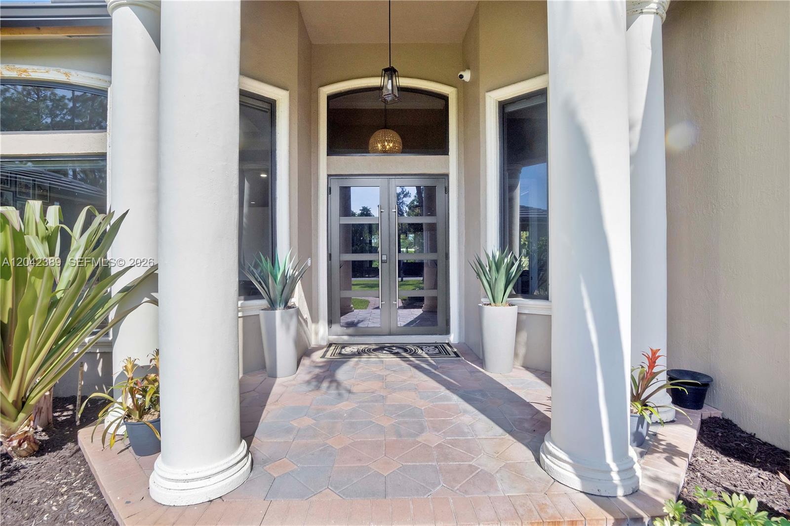 A covered entryway features double glass doors, two large columns, and potted plants — 5755 NW 72nd Way, Parkland FL 33067, PARKLAND, FL
