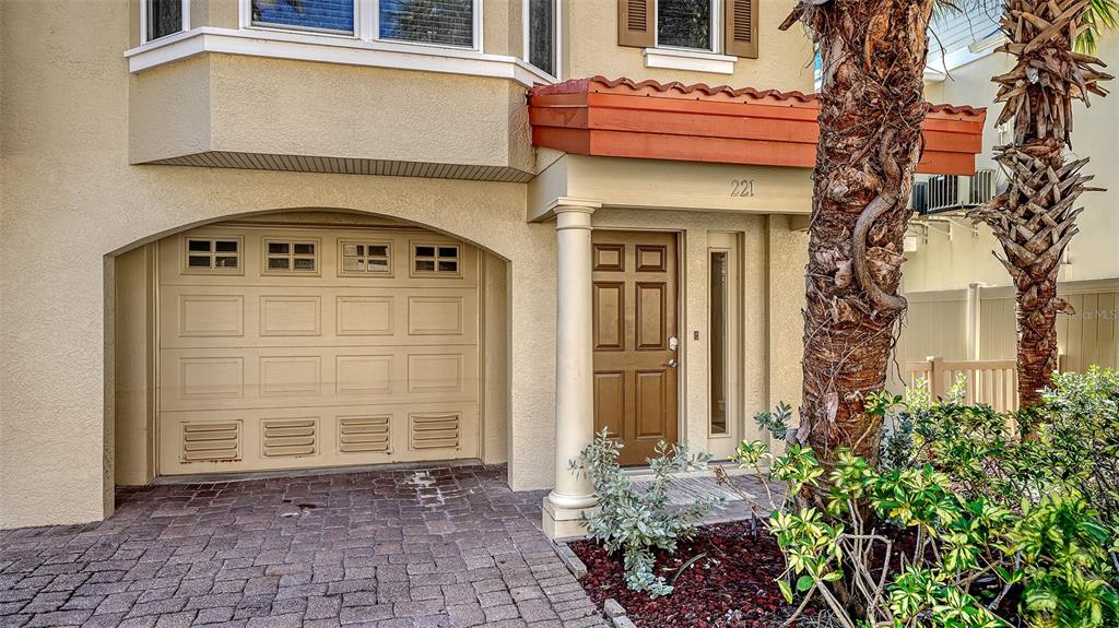 The exterior of a house features a garage, a front door, and a palm tree — 221 17TH STREET N, BRADENTON BEACH, FL
