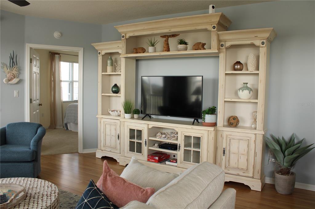 A living room features a large, distressed white entertainment center and a blue armchair — 2625 TERRA CEIA BAY BOULEVARD UNIT 401, PALMETTO, FL