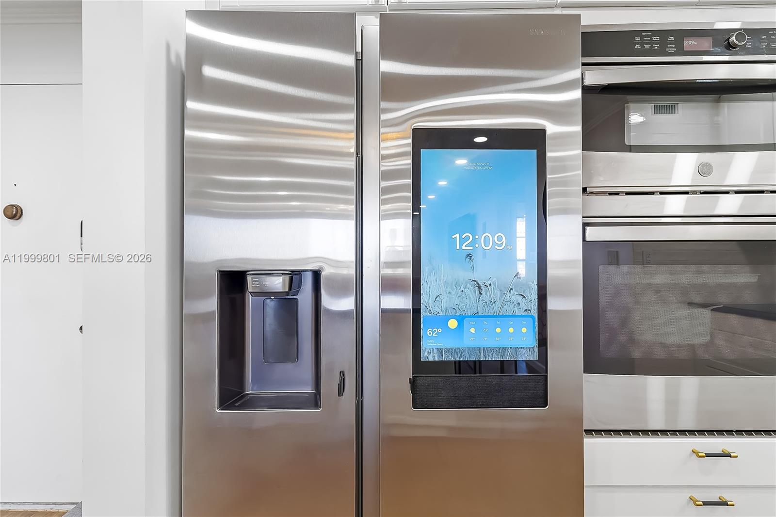 A stainless steel Samsung smart refrigerator is positioned next to a built-in wall oven — 600 Three Islands Blvd # 604, Hallandale Beach FL 33009, HALLANDALE BEACH, FL