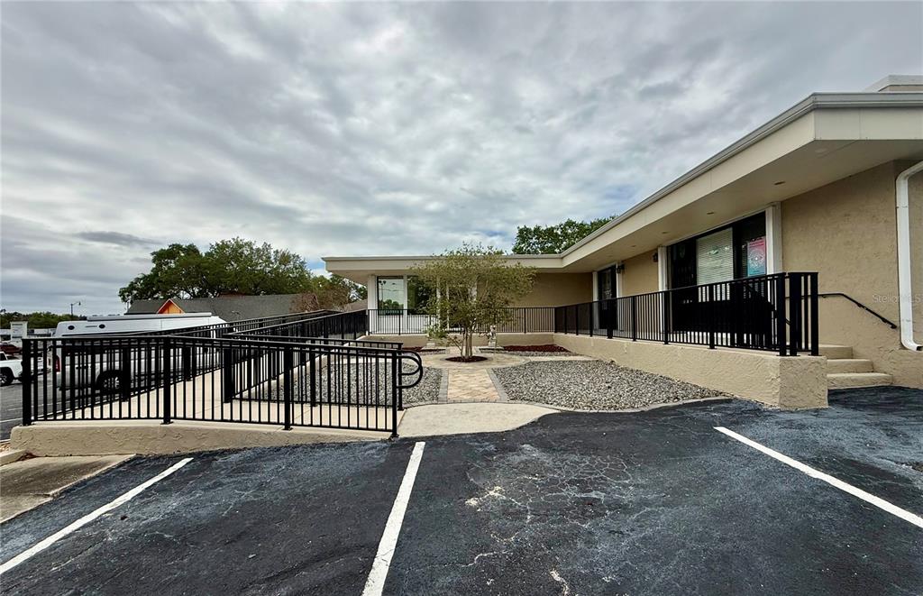 An exterior view of a commercial building with a wheelchair ramp and a central courtyard — 220 CORAL SANDS DRIVE, ROCKLEDGE, FL
