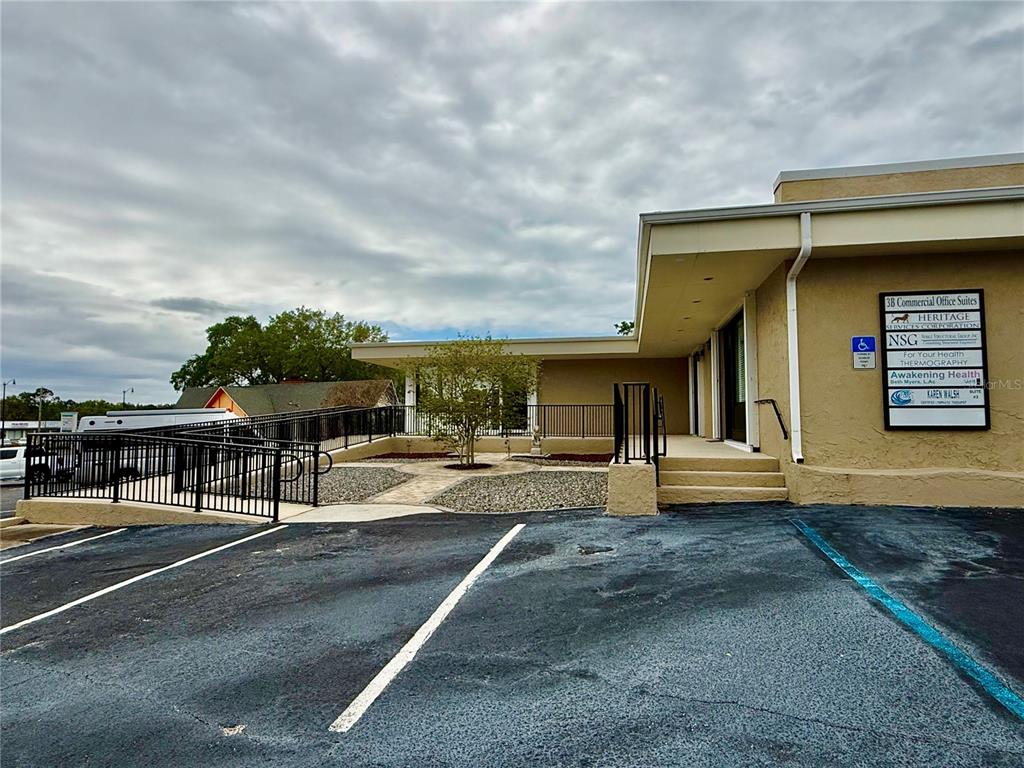 A commercial office building exterior features a wheelchair ramp, stairs, and a directory sign — 220 CORAL SANDS DRIVE, ROCKLEDGE, FL