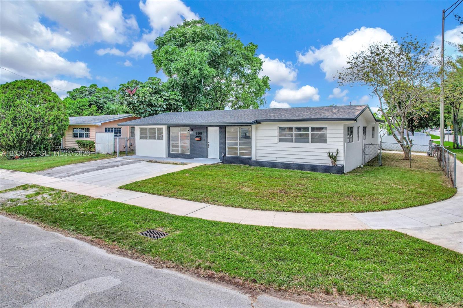 A single-story house with white siding and a dark gray entryway sits on a corner lot — 8201 SW 42nd St, Miami FL 33155, MIAMI, FL