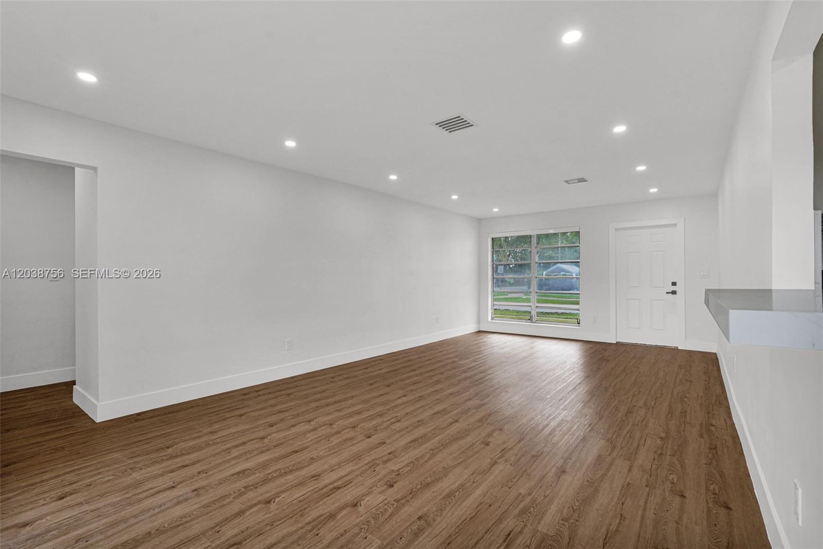 An empty room features white walls, recessed lighting, and wood-look flooring — 8201 SW 42nd St, Miami FL 33155, MIAMI, FL