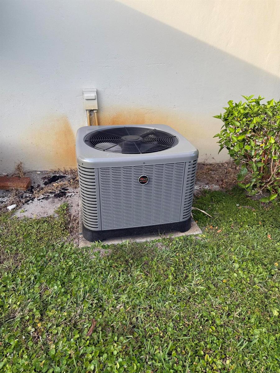 A Ruud air conditioning unit sits on a concrete pad against a beige exterior wall — 3311 Valley Road # D, Boynton Beach FL 33435, BOYNTON BEACH, FL