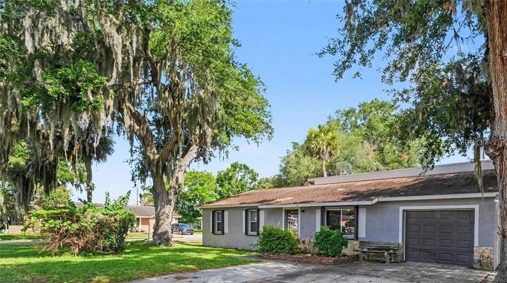 A single-story house with a gray exterior, a garage, and large trees with Spanish moss — 838 GEORGIA AVENUE, ROCKLEDGE, FL