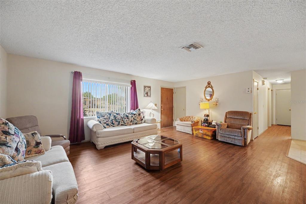 A living room features wood-look flooring, a white sofa, two armchairs, and a coffee table — 838 GEORGIA AVENUE, ROCKLEDGE, FL