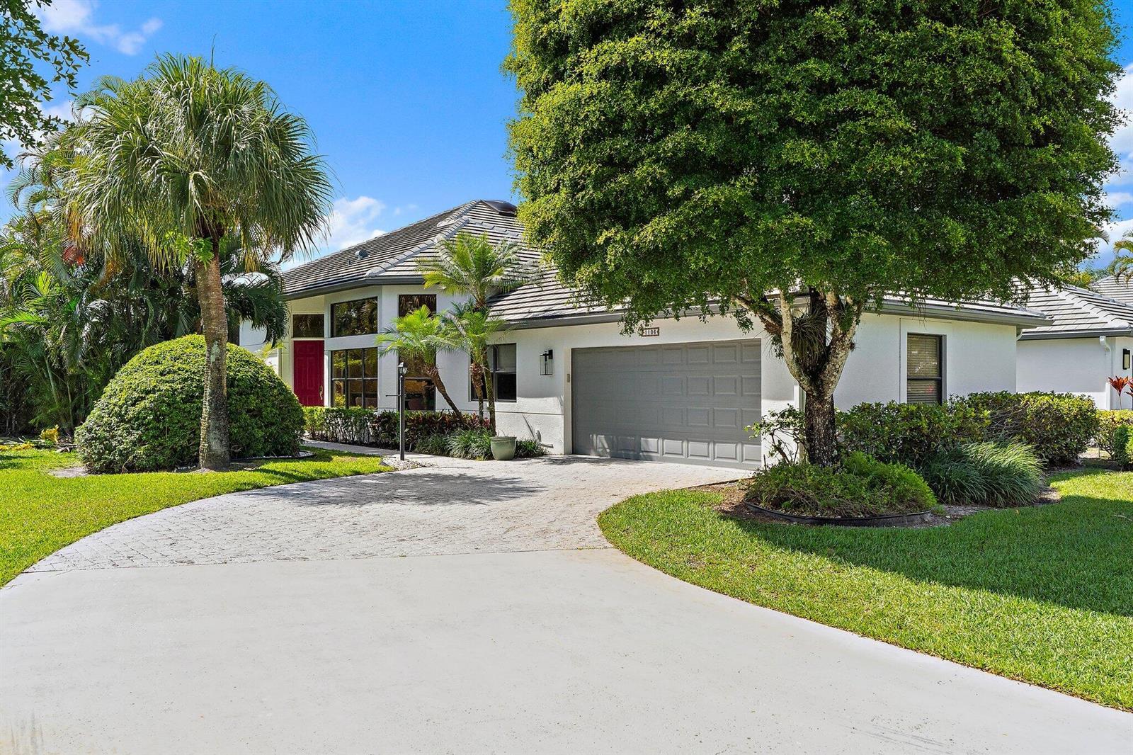 A single-story house with a white exterior, gray garage door, and a paved driveway — 1106 Sand Drift Way # A, West Palm Beach FL 33411, WEST PALM BEACH, FL