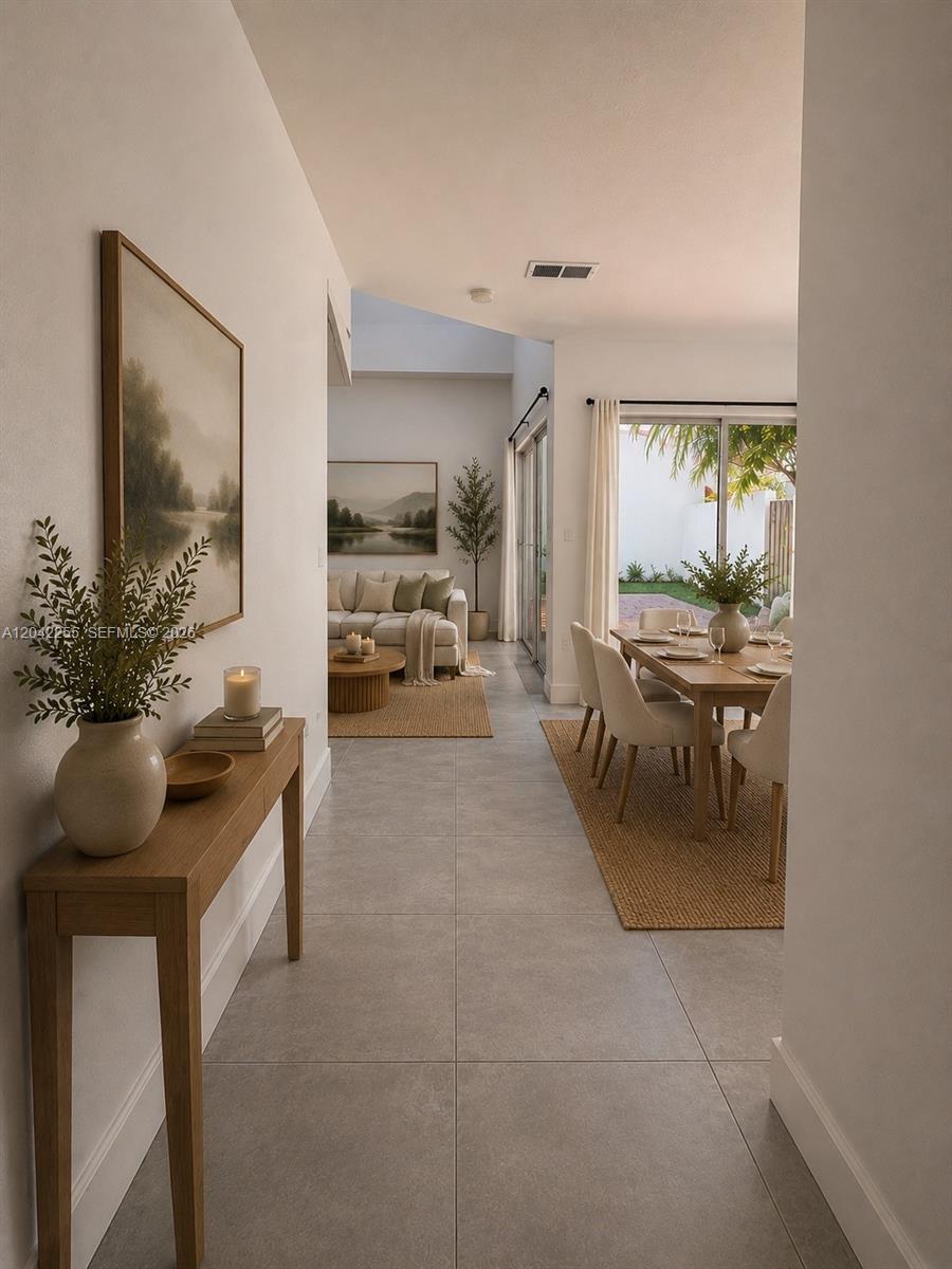A view from a hallway into a dining area and living room with tile floors — 14912 SW 104th St # 48, Miami FL 33196, MIAMI, FL
