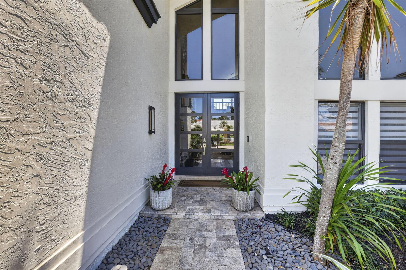 The exterior entrance features a double glass door, stone walkway, and two potted bromeliad plants — 2920 NE 47th Street, Lighthouse Point FL 33064, LIGHTHOUSE POINT, FL