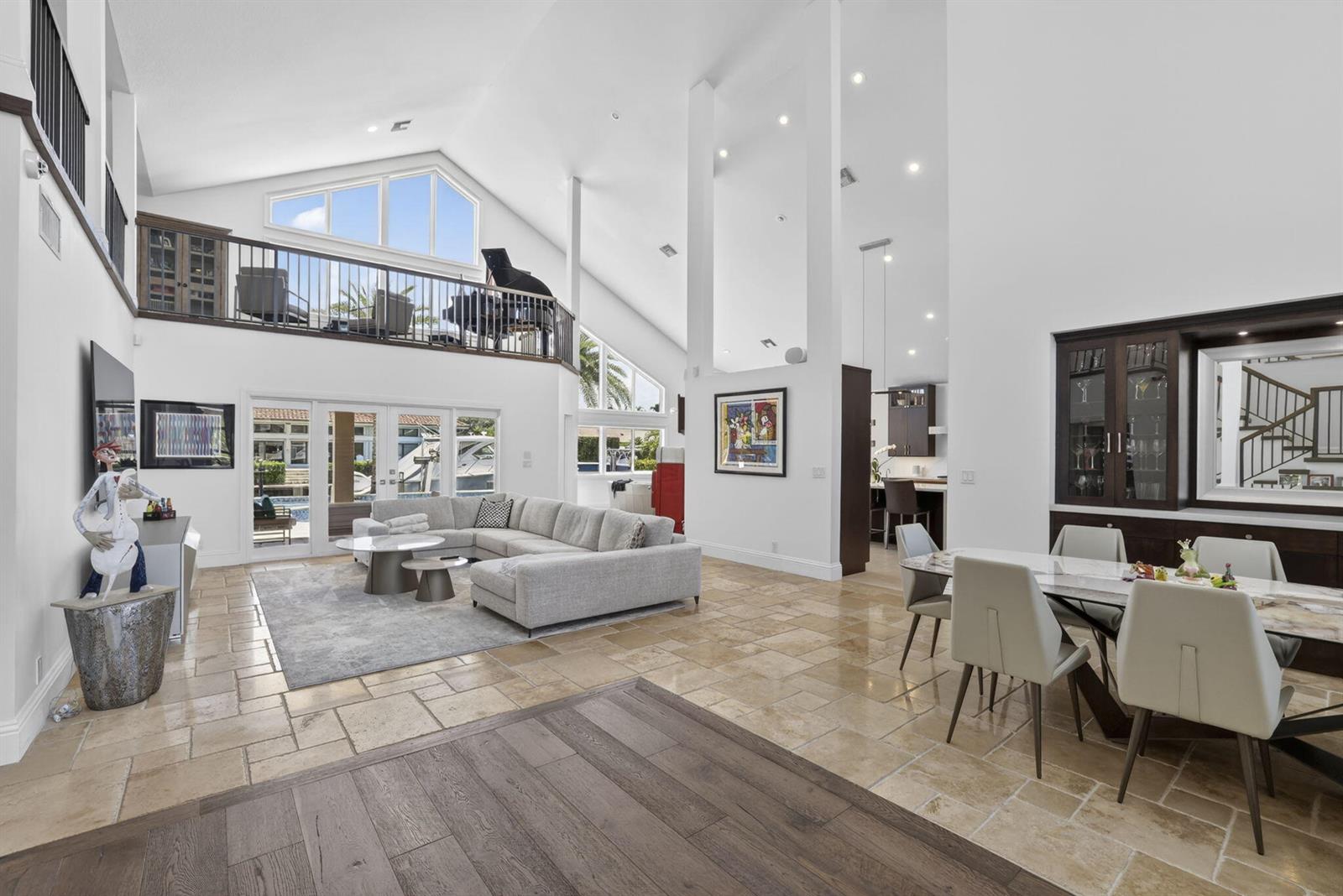 A spacious living and dining area features vaulted ceilings, tile flooring, and a lofted balcony — 2920 NE 47th Street, Lighthouse Point FL 33064, LIGHTHOUSE POINT, FL