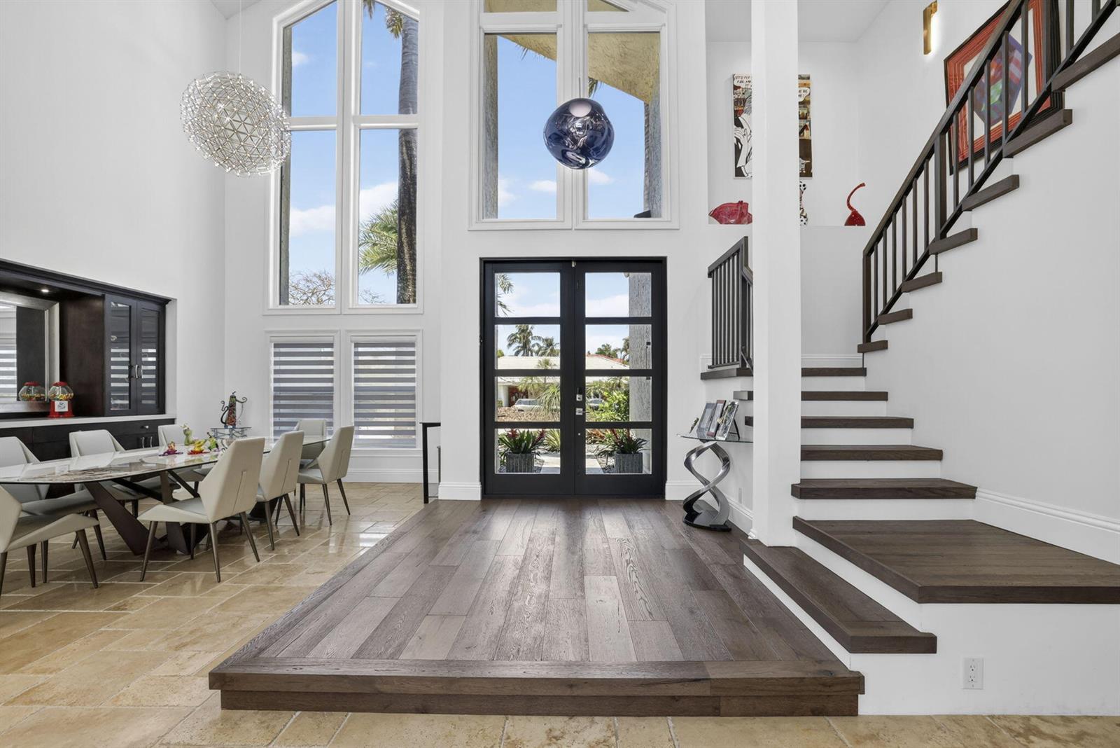 A bright entryway features a raised wood floor, a double door, and a staircase — 2920 NE 47th Street, Lighthouse Point FL 33064, LIGHTHOUSE POINT, FL