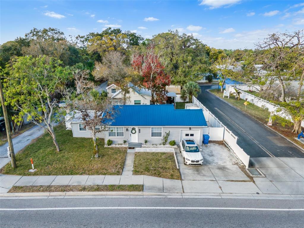 An aerial view of a single-story house with a blue metal roof and driveway — 7799 46TH AVE N, ST PETERSBURG, FL