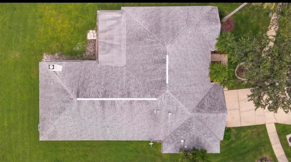 An aerial view shows the shingled roof of a residential house with a flat section — 29619 ALLEGRO DRIVE, WESLEY CHAPEL, FL