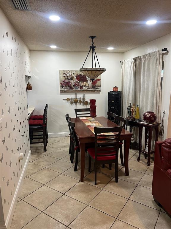 A dining room features a wooden table, red-cushioned chairs, a chandelier, and butterfly wall decals — 437 HUNTER CIRCLE, KISSIMMEE, FL