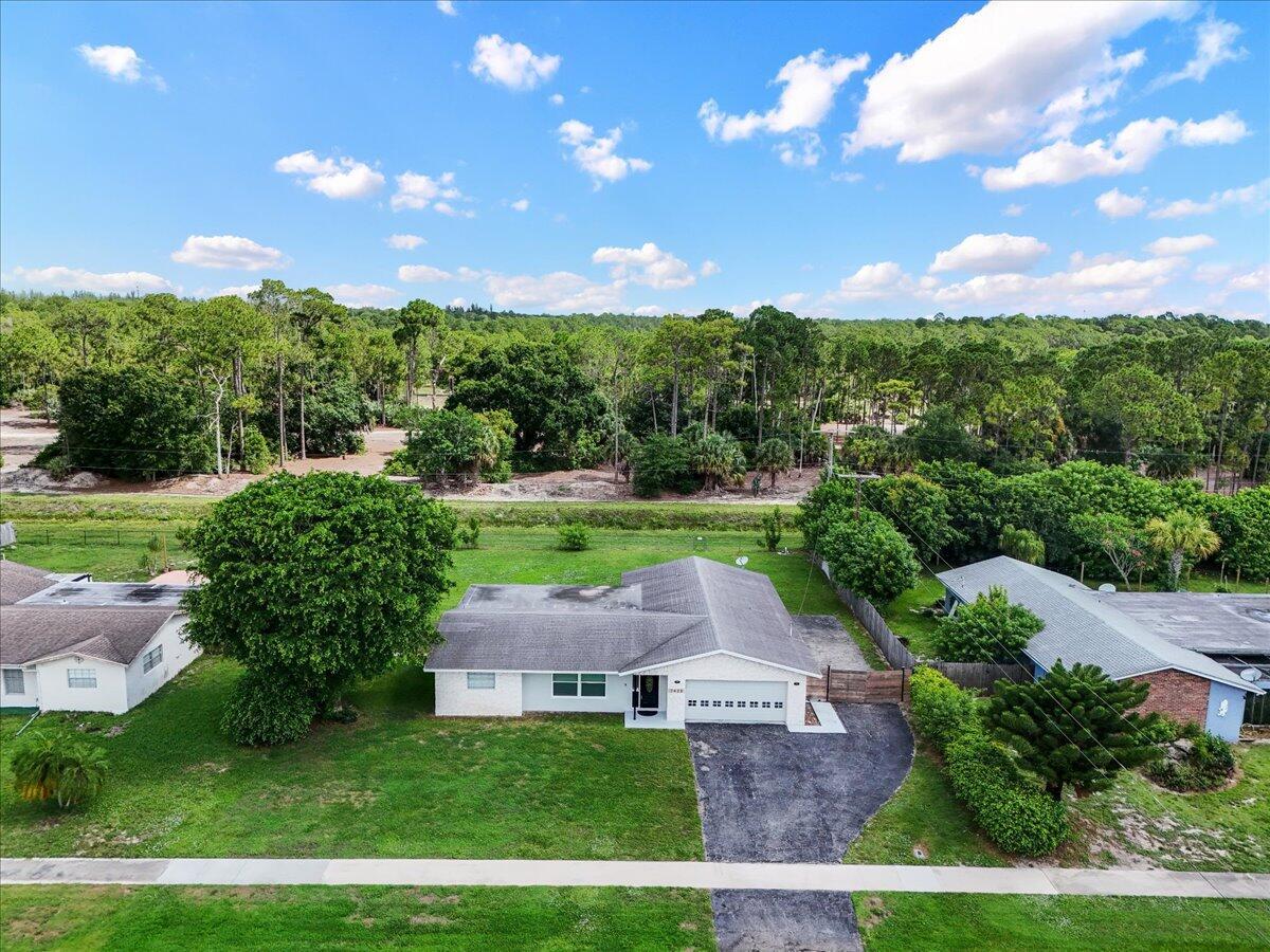 An aerial view shows a single-story house with a white exterior and a gray roof — 7423 Oakmont Drive, FL 33467, FL