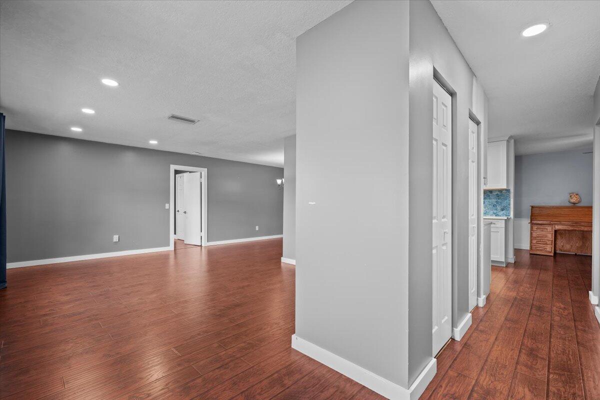 An interior view shows a living area with wood floors and a hallway with closets — 7423 Oakmont Drive, FL 33467, FL