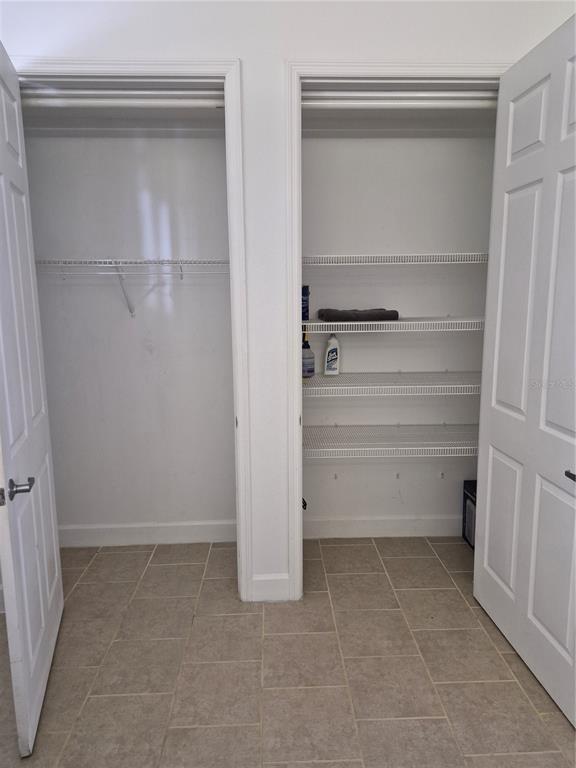 Two side-by-side closets with white doors, wire shelving, and light-colored tile flooring — 2080 HERITAGE KEY BOULEVARD, KISSIMMEE, FL