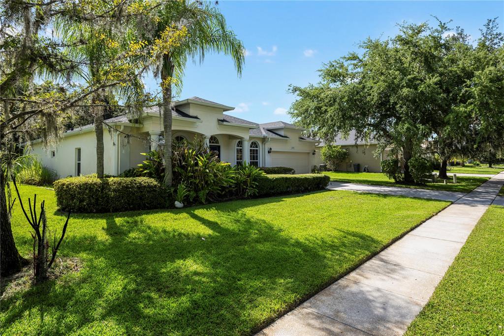 A single-story house with a beige exterior, a two-car garage, and a manicured front lawn — 3192 WATERBRIDGE LANE, KISSIMMEE, FL