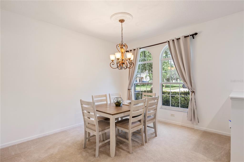 A grassy backyard features a large oak tree and a white vinyl privacy fence — 3192 WATERBRIDGE LANE, KISSIMMEE, FL